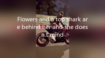 Flowers and a top shark are behind her and she doesn.t mind